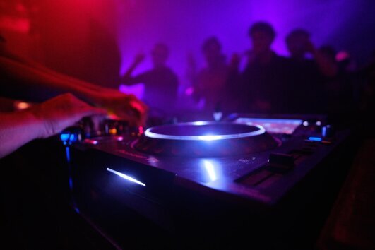 closeup_shot_dj_s_equipment_people_dancing_club